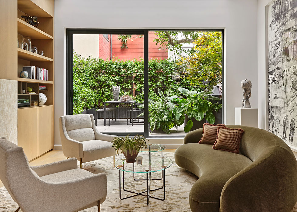 Wide shot of a modern and luxurious Brooklyn living room with tall sliding glass doors that lead to a lush private garden.