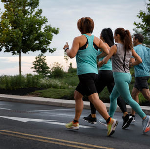 Atletas participando de corrida de rua em São José do Rio Preto com estrutura profissional de evento esportivo, pórtico de largada e público acompanhando.