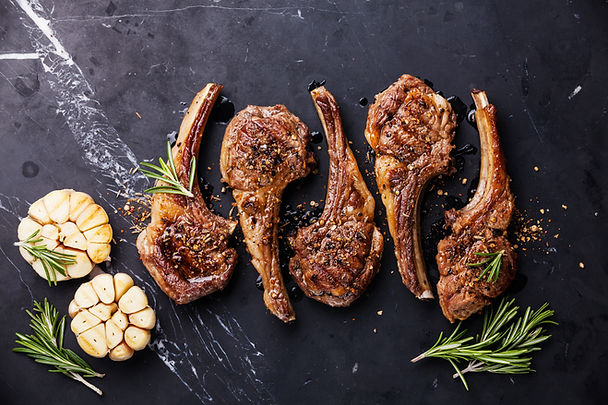 Roasted lamb ribs with spices and garlic on black marble background.jpg