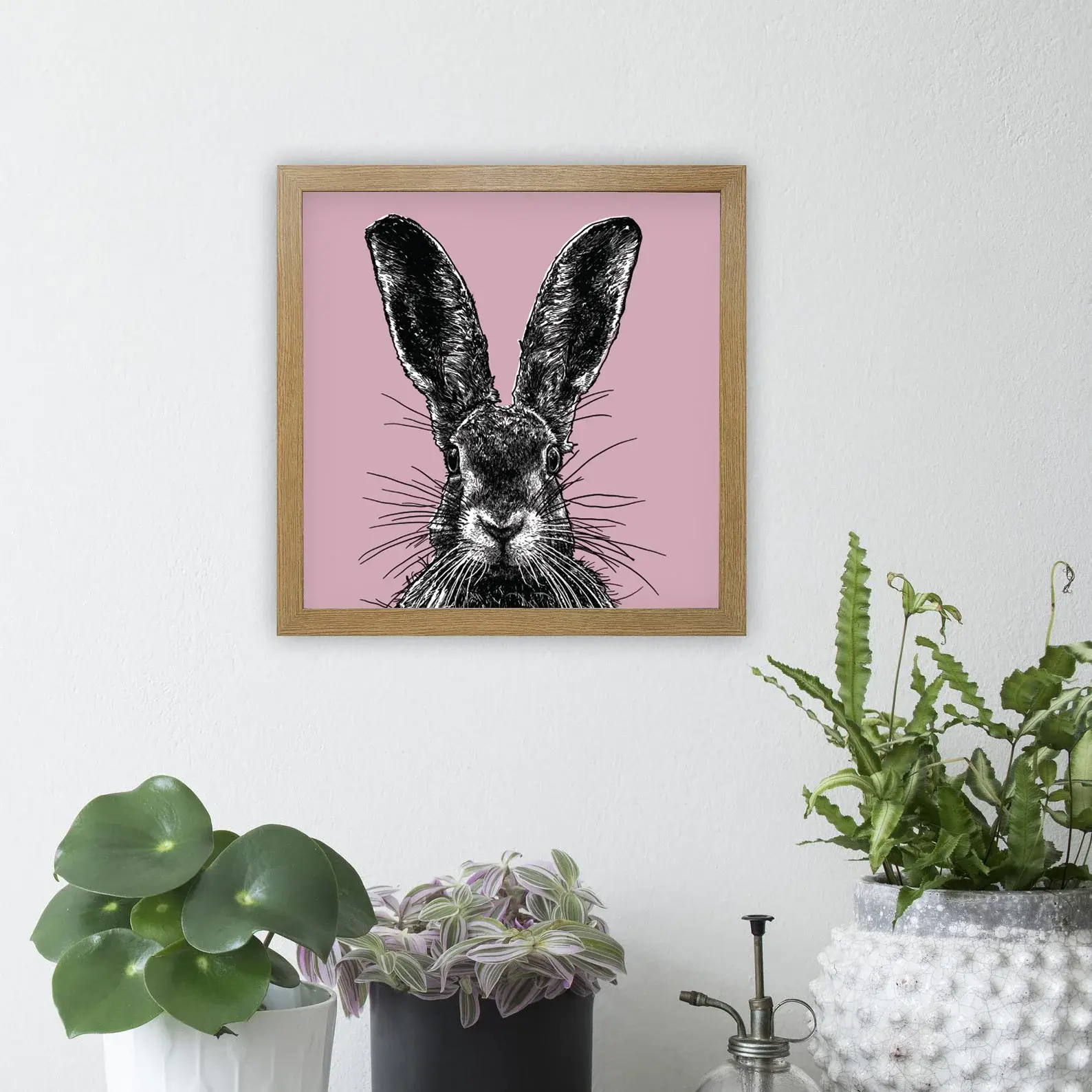 Wooden framed print of illustrated hare on pink background.