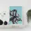 Thumbnail: (white) framed print of illustrated octopus on blue background.