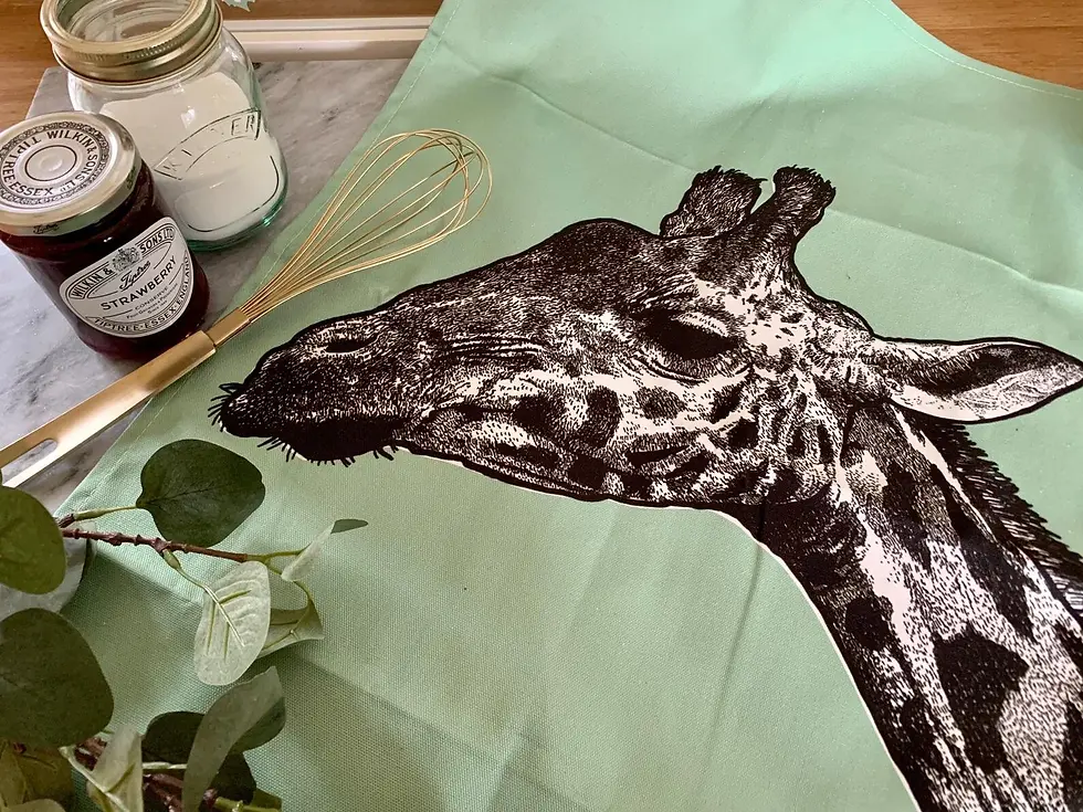 Cotton tea towel with a print of a hand-drawn illustrated giraffe on a green background.