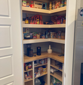 Custom corner pantry with organized white and wood shelves