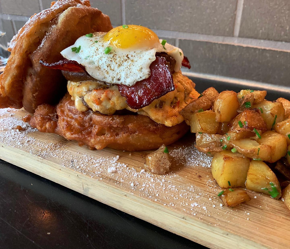 Picture of hash browns and a brunch burger with french toast and a fried egg and bacon on top