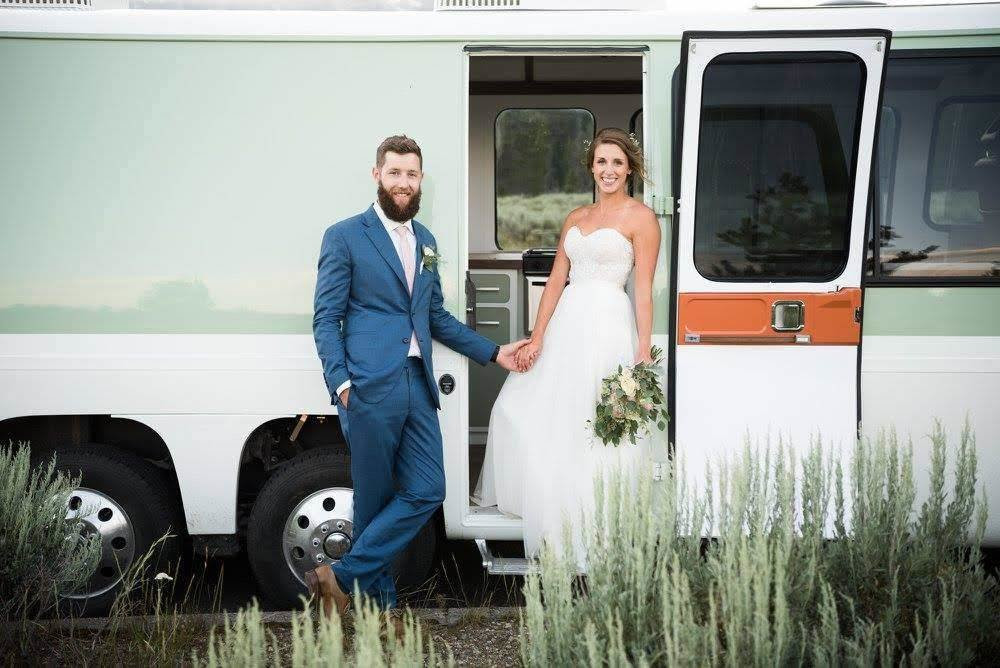Bridal couple standing in front of an RV.