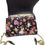 Thumbnail: Back of Loungefly Alice in Wonderland satchel with floral character print on black faux leather