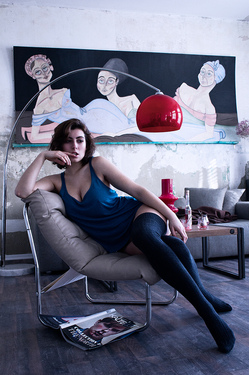 Eine junge Frau sitzt auf einem Sessel. werdio