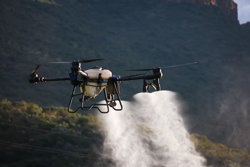 Drone spraying a white mist over a green mountainside, with dark cliffs in the background.