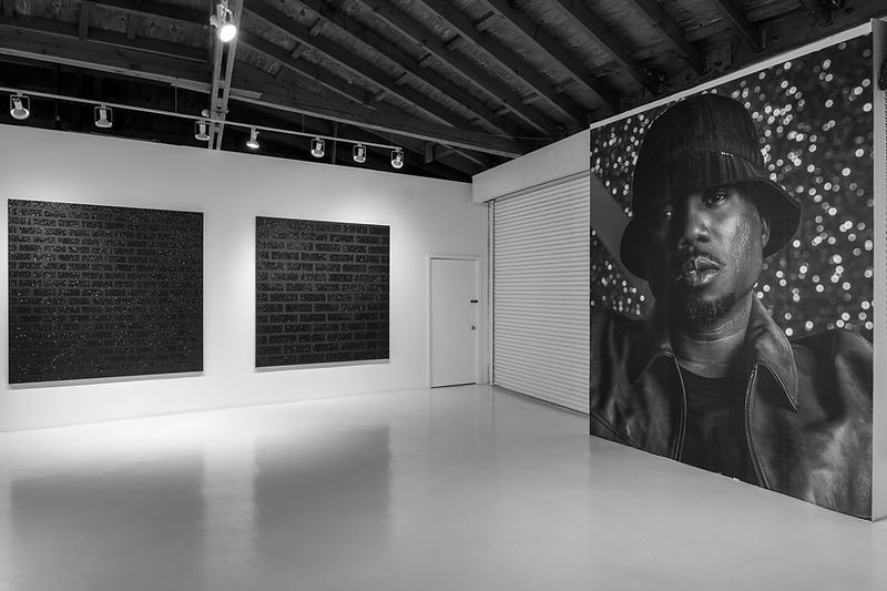 Humbled Beginnings installation with brick wall paintings and self portrait