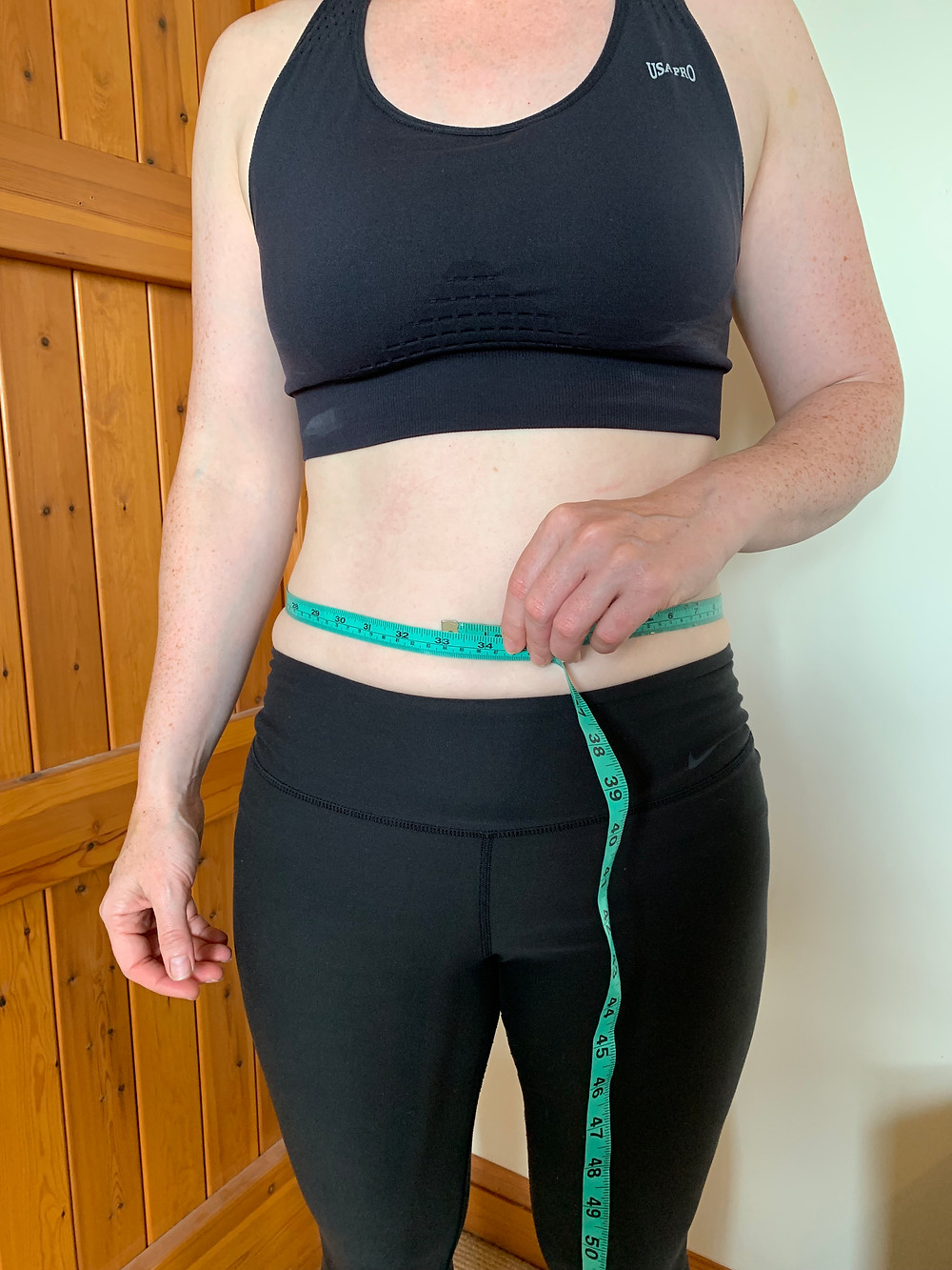 female tape measurement of stomach at belly button