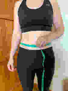 female tape measurement of stomach at belly button