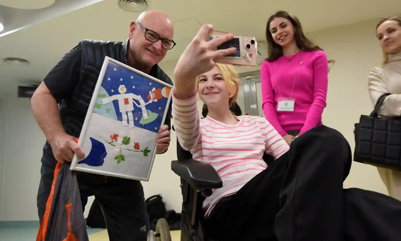 Retired Nasa astronaut Scott Kelly with Kateryna Iorhu, 13, who was injured and lost her m
