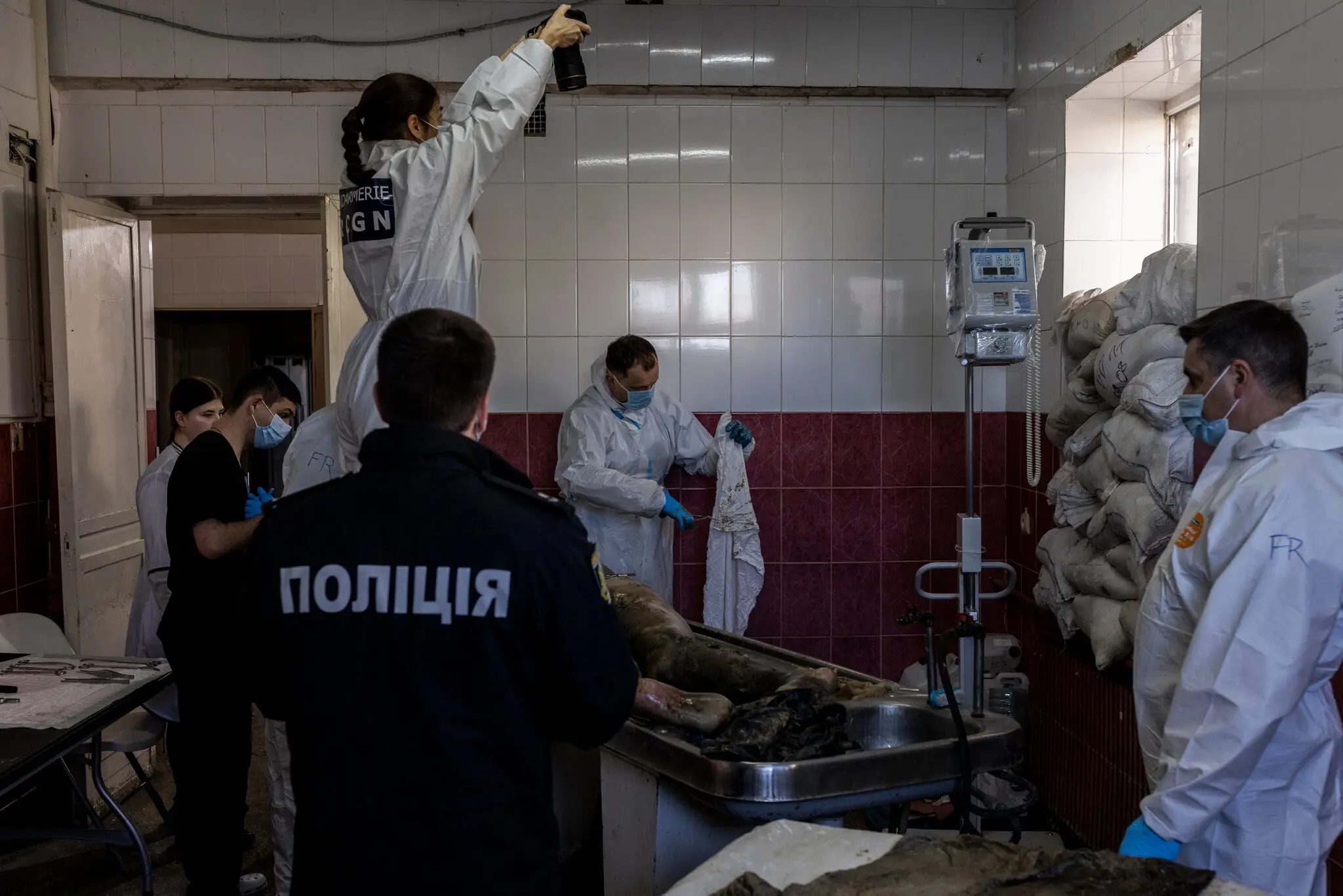 French and Ukrainian forensic experts documenting the wounds on Serhii Avdeev’s body..webp