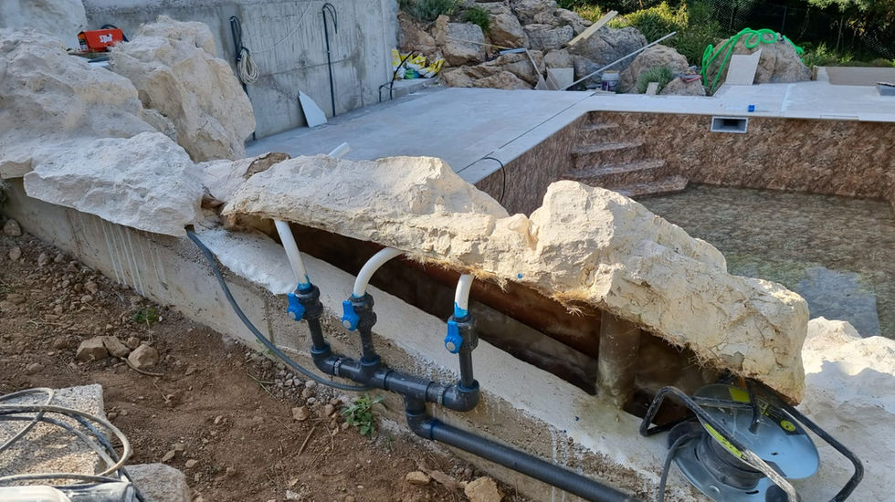 Application of faux polyester rocks on concrete wall