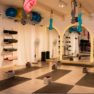 Eye-level view of a serene Abuja yoga studio with natural light and mats set-up with props
