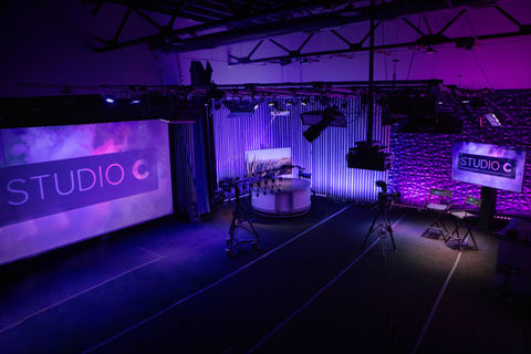 Interior of Studio C by Chronicle Cinema in Jeffersonville, Indiana, the Louisville, Kentucky area’s top film and video production studio, featuring a projector screen, motorized jib, podcast setup, and flexible studio space available for hourly rental.