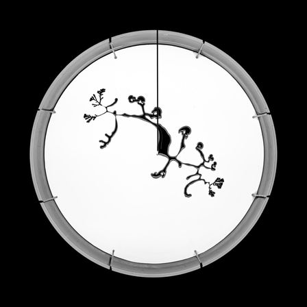 A print of black liquid on a white circle contrasting with the black background