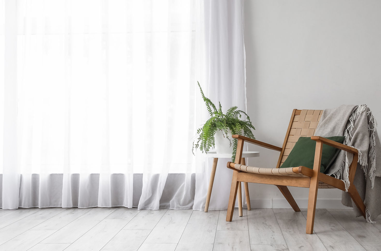 Table with houseplant and armchair near light curtain in room_edited.jpg