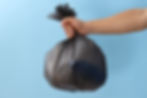 garbage-bag-with-rubbish-hand-blue-background.jpg