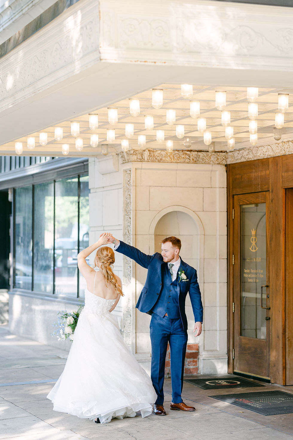 Groom twirling bride outside of hotel in San Fransisco, California, wedding photo by Lauren Makenna Photography
