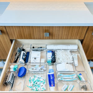 Bathroom toiletries organized in a drawer with clear drawer organizers