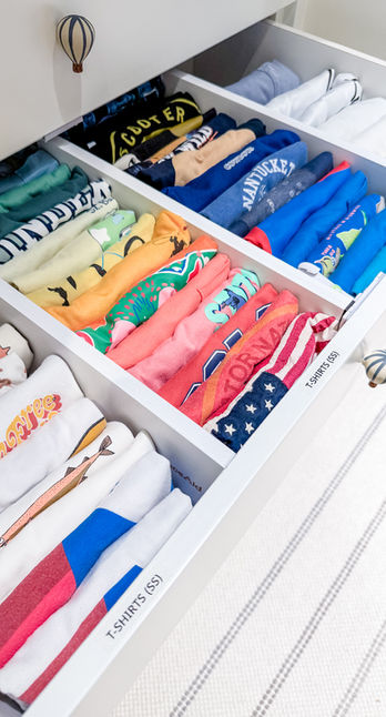 A little boy's t-shirt drawer divided by type and file folded by color. Aspen, CO.