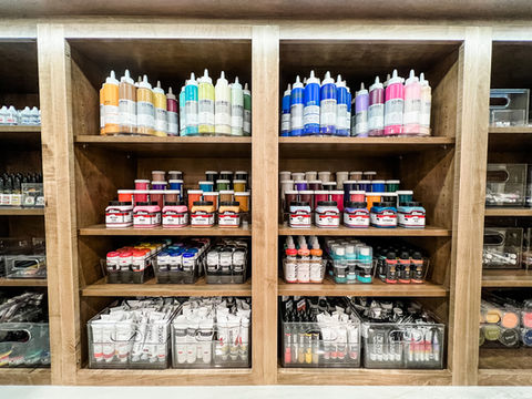 Paint organizing by type and color on luxury wood shelves