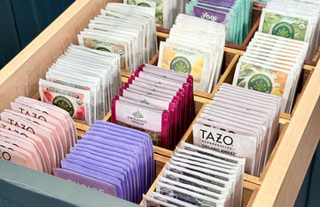 Tea bags organized by type in a drawer within bamboo compartments.