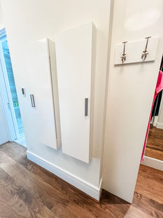 Custom jewelry cabinet next to a custom ironing board cabinet by Closet Factory