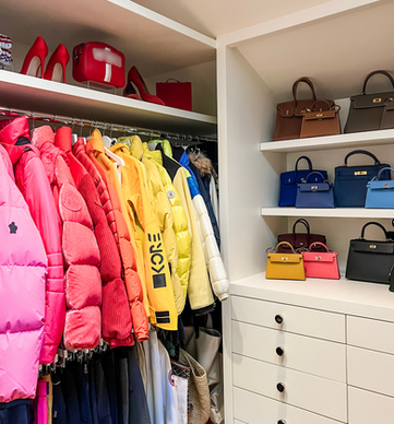 Bright ski jackets and hand bags organized in a luxury women's closet