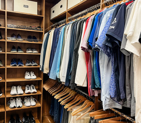 Men's closet with color-coordinated clothing, shoe shelving, and Neat Method storage bins by KO Luxury Organizing in Cherry Hills Village, CO