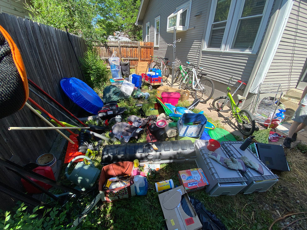 Behind-the-scenes of the organizing process showing all belongings from a garage on the back lawn organized by category