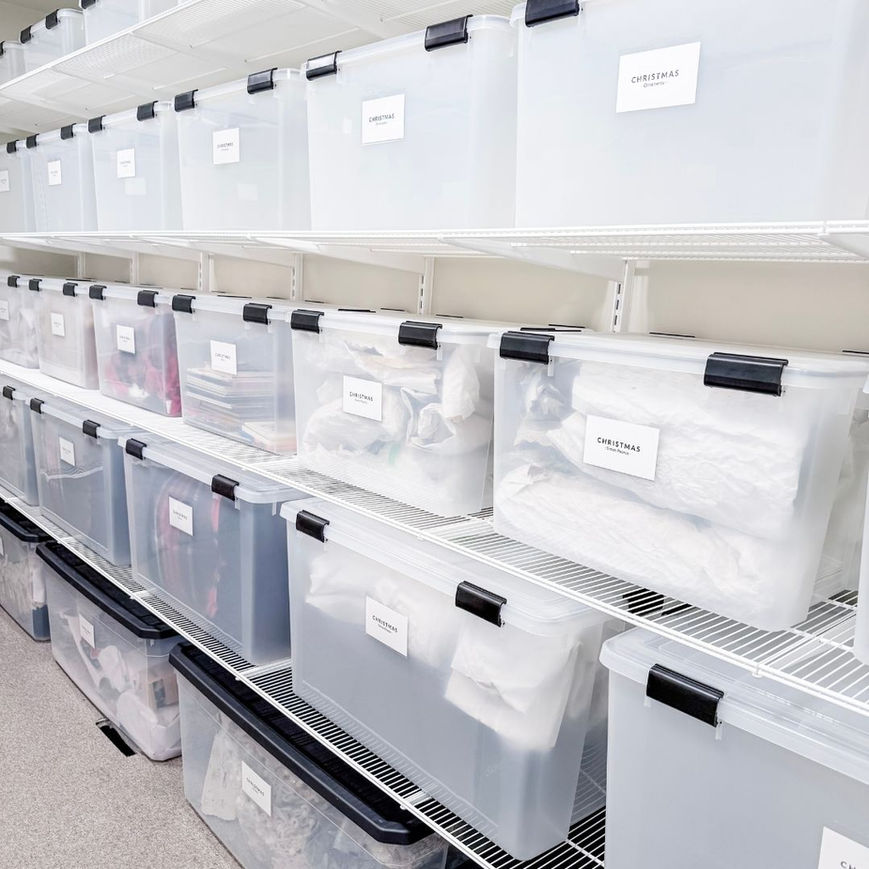 Luxury storage room organized with white Elfa shelving and clear Weathertight Totes from The Container Store