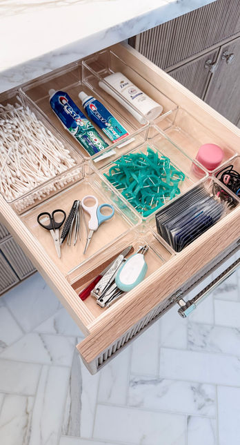A custom wood bathroom drawer with clear acrylic dividers organizing toothbrushes, toothpaste, scissors, and small accessories — organized by KO Luxury Organizing in Denver.