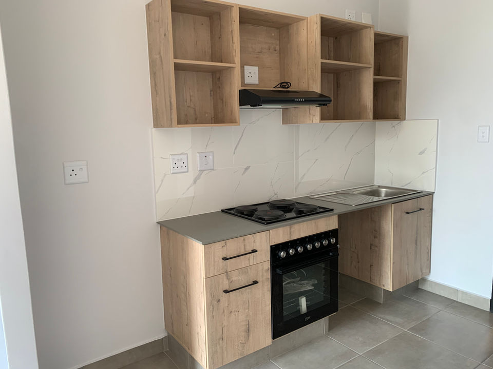 Stylish kitchen with built-in cupboards and modern finishes in a Sandton bachelor apartment at View on Bowling.