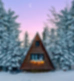 A cabin in a snow-filled field at dusk