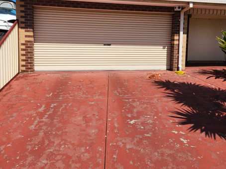A concrete driveway that has years of sealing product built up on it.