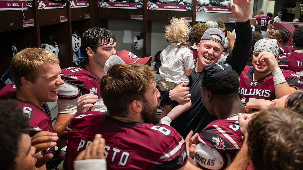 Linebackers celebrate a win over Thomas More with Coach Mac and his son, Brooks.