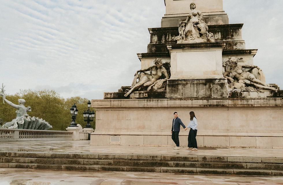 Couple marchant devant le monument des Girondins sur la Place des Quinconces à Bordeaux, un lieu idéal pour une séance photo en extérieur.