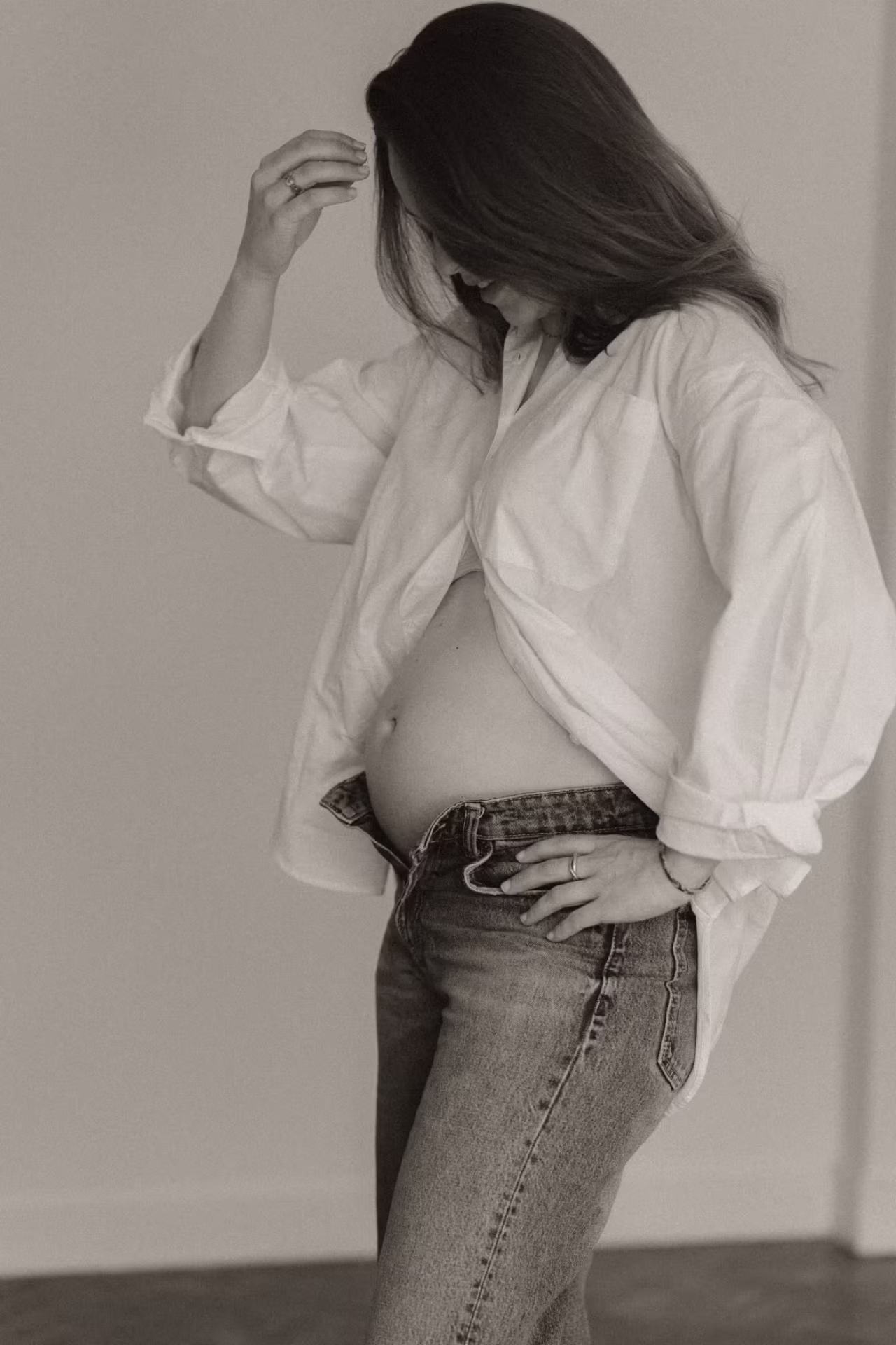 Portrait en noir et blanc d'une future maman dévoilant son ventre rond lors d'une séance grossesse