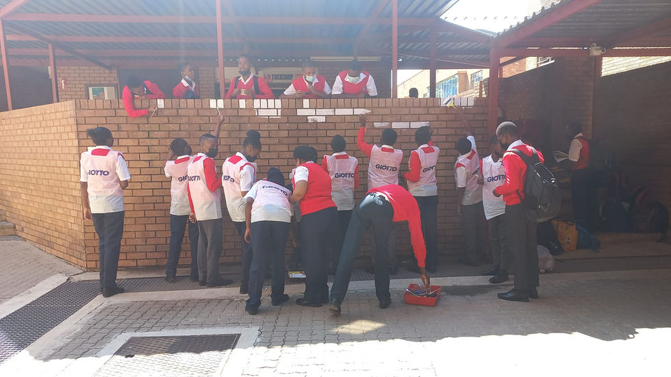 Learners of PTHS participating in painting a mural for their school.