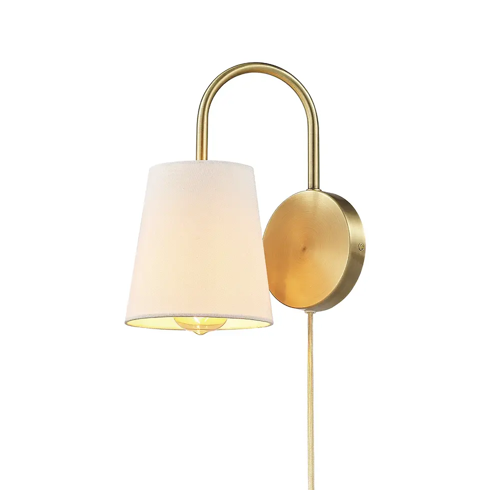 Close-up of wall sconce featuring a curved brass arm and white tapered fabric shade with a visible light bulb.