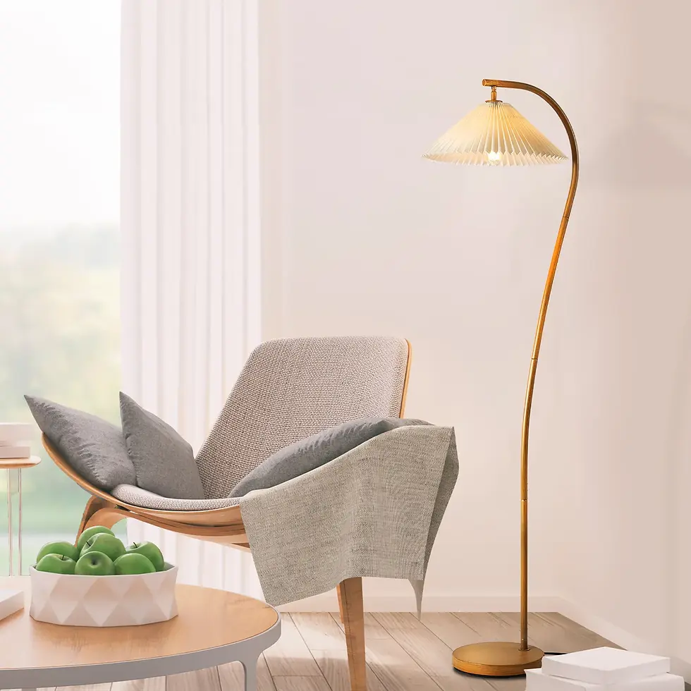 Floor lamp with warm light next to a modern reading chair draped with a grey throw blanket and pillows.