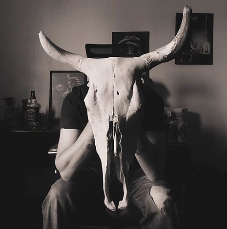 Uma selfie de um homem segurando uma caveira bovina de chifres
