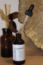 LinaPin sandalwood hair oil bottle with dropper and decorative background.