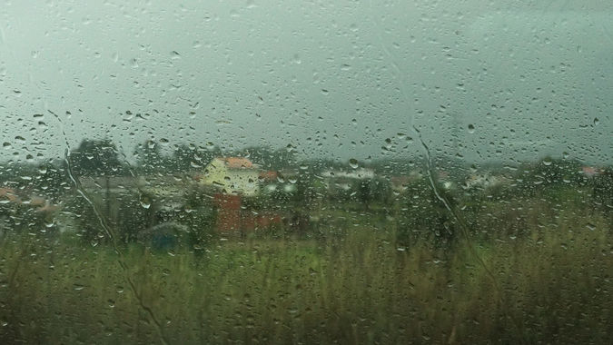 Rainy view of houses through wet, train window, enroute to Porto, Portugal