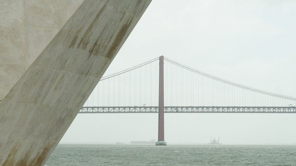25 de Abril Suspension bridge with concrete pillar in foreground, Lisbon, Portugal.