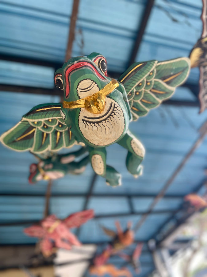Green winged frog wood carving hanging in shop in Nyuh Kuning, Ubud, Bali