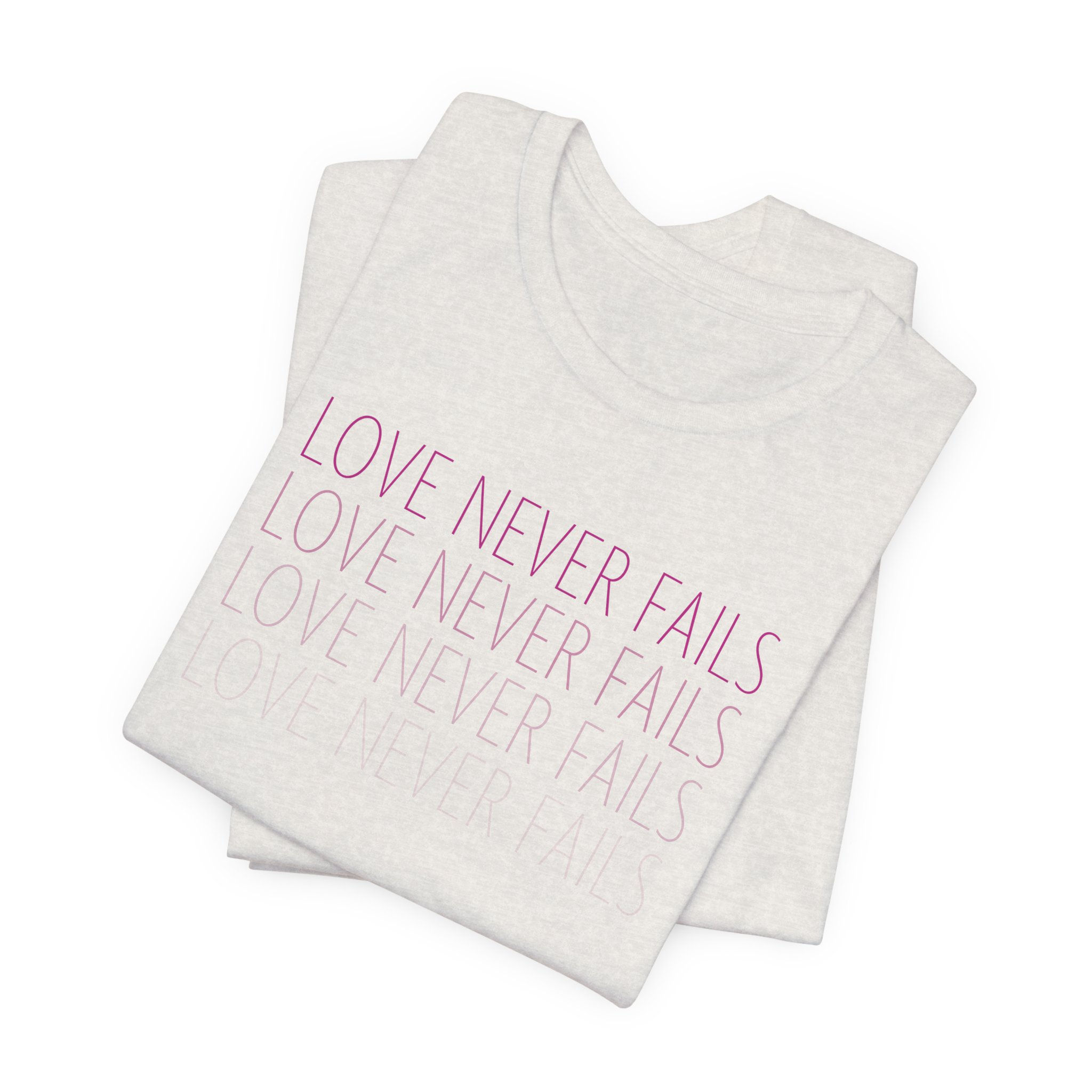 Love Never Fails Heather Cement Tee with Pink Text