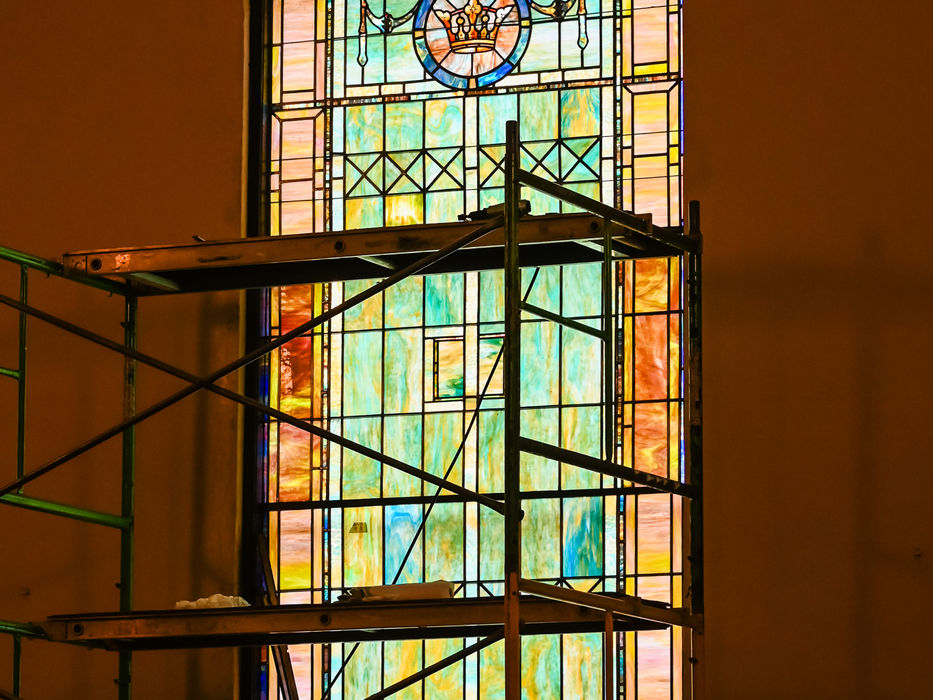 Colorful arched stained glass window with scaffolding